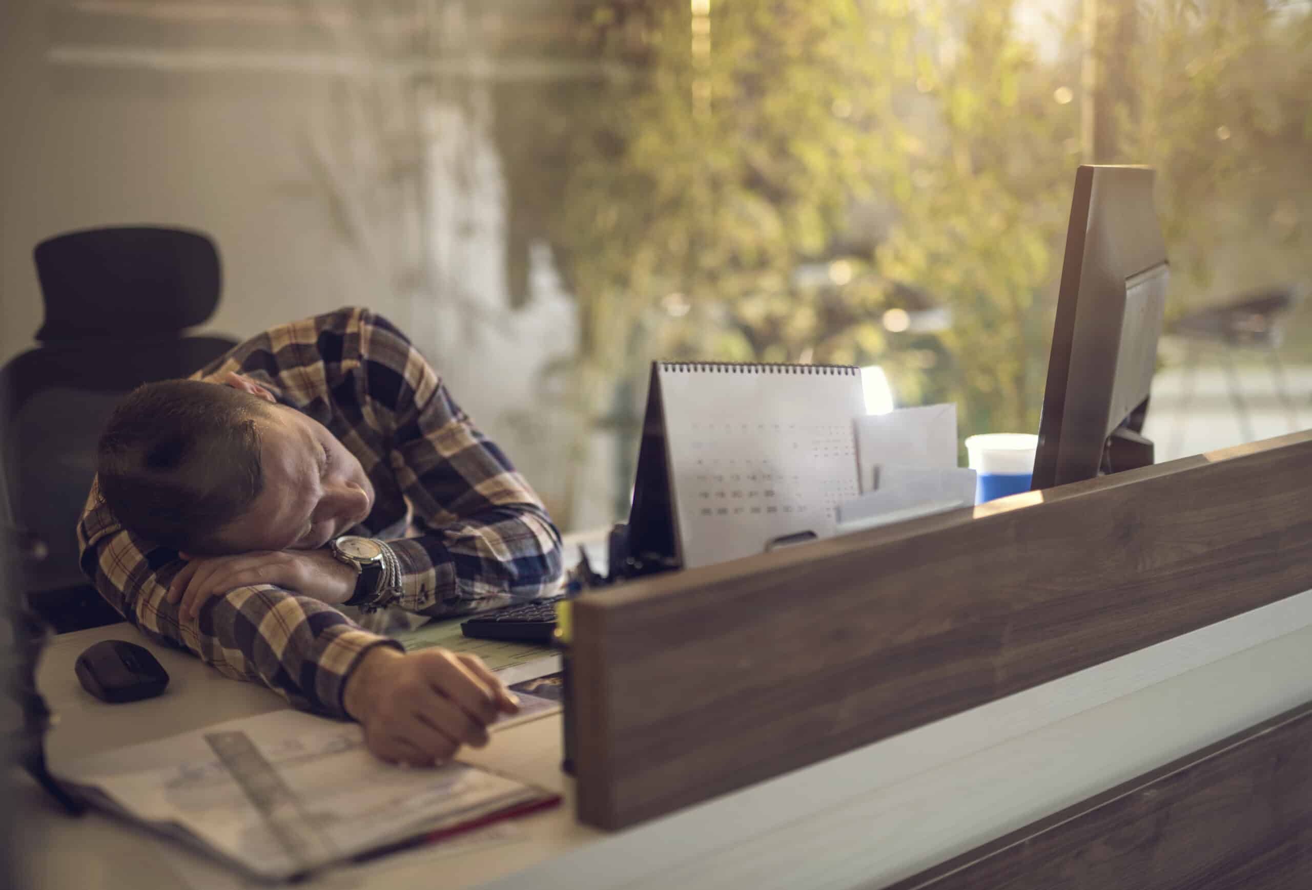 Mann sover på pulten