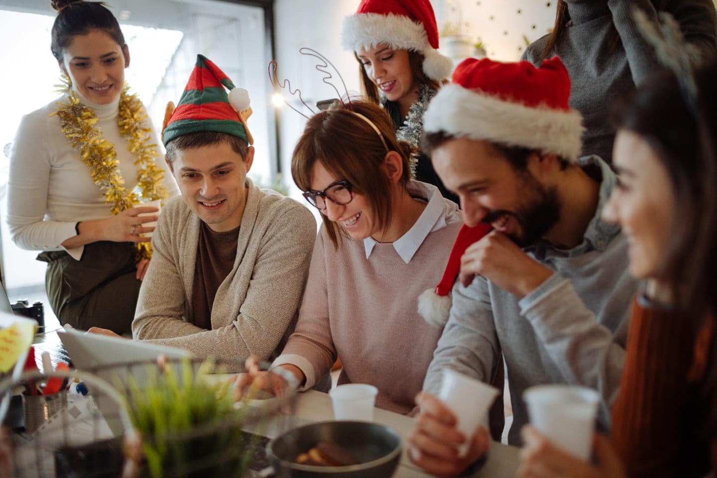kolleger som koser seg med julekort og juleforberedelser på jobb