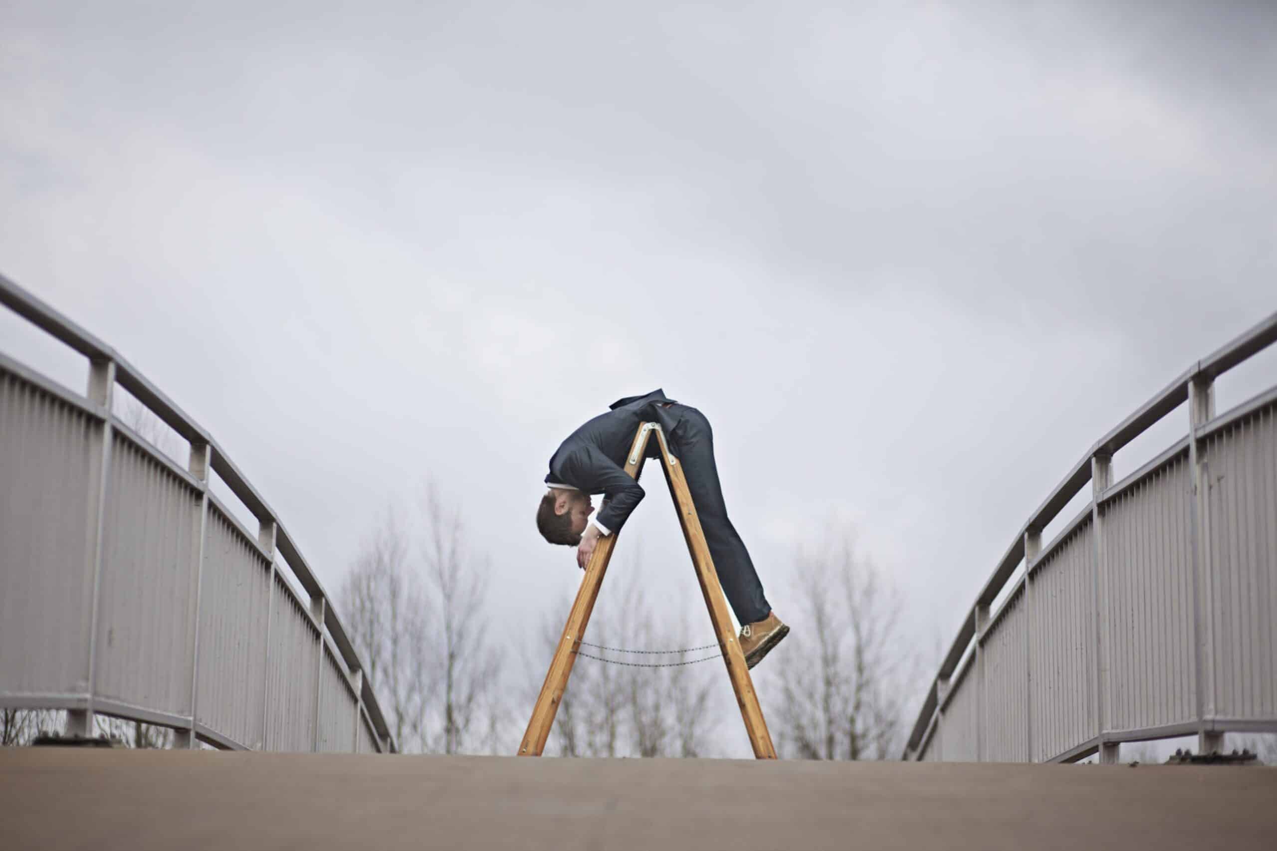 Mann ligger bøyd over en vinklet stige, karriere