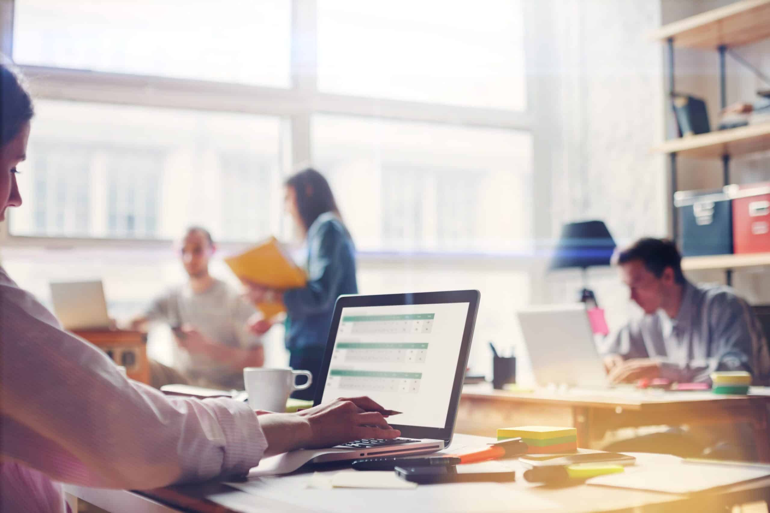 Flere medarbeidere som sitter i jobblandskap