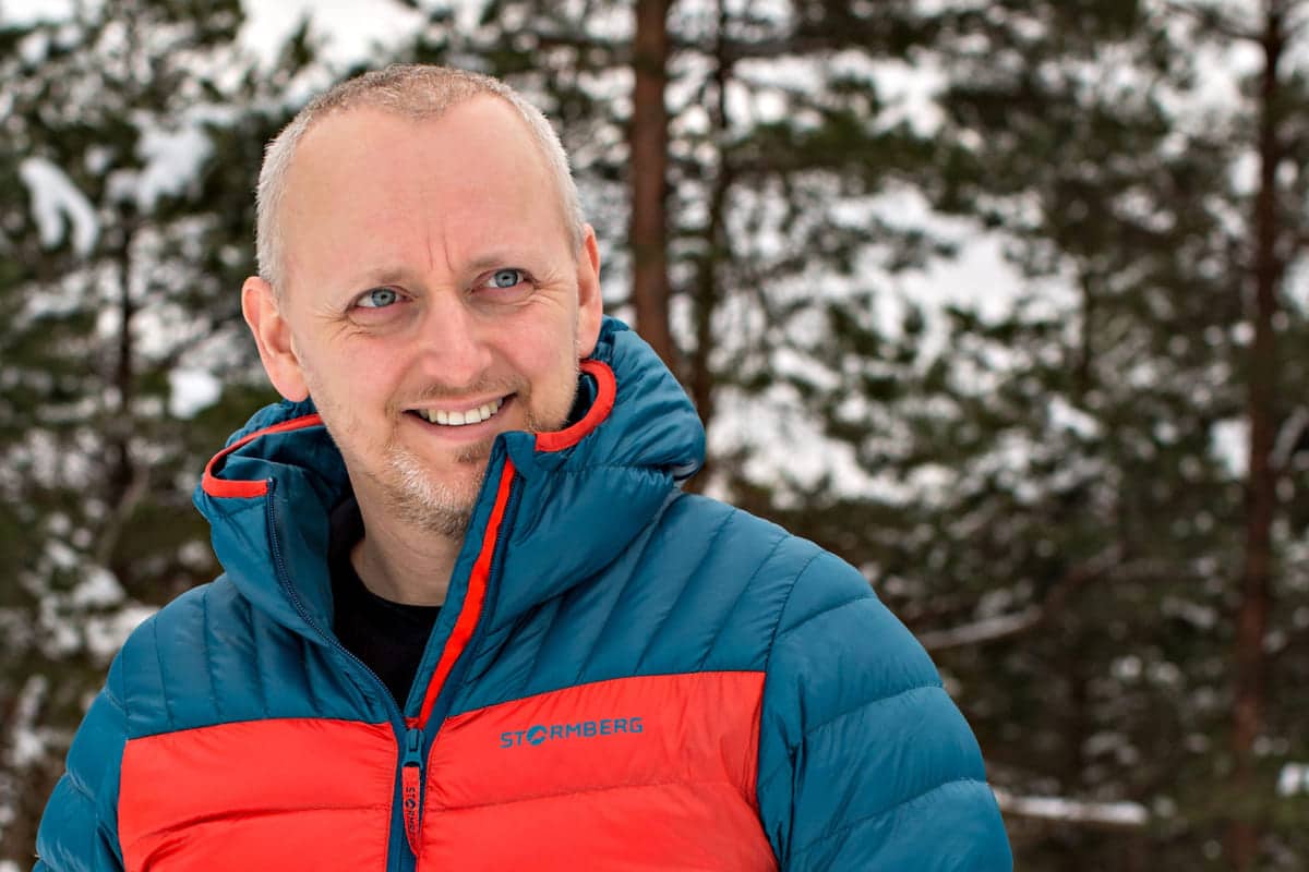 Inkluderende arbeidsliv: Blid mann i boblejakke ser til siden.