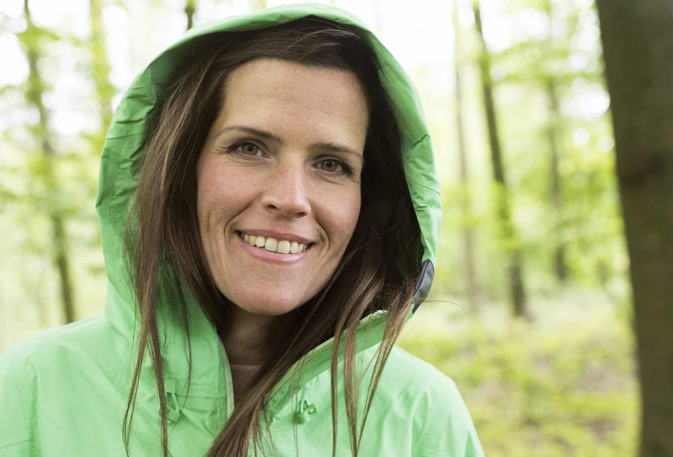 Denne kvinnen er ikke utbrent. Hun ser frisk og sunn ut, på tur i grønn hettejakke.