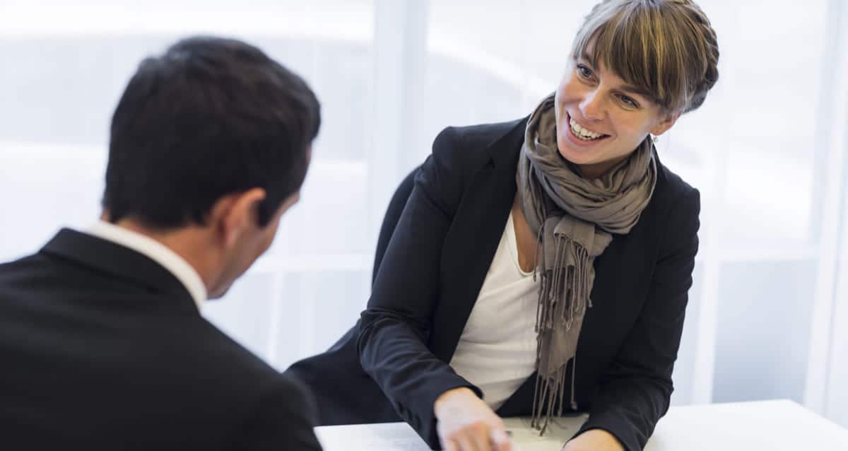 Sluttsamtale: En blid kvinne i samtale med en mann med ryggen til.