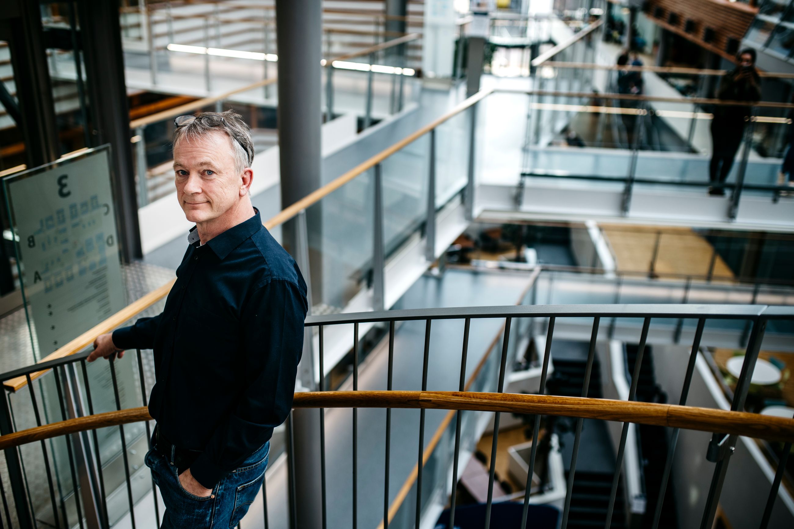 Organiasjon: En mann står høyt oppe i et moderne bygg.