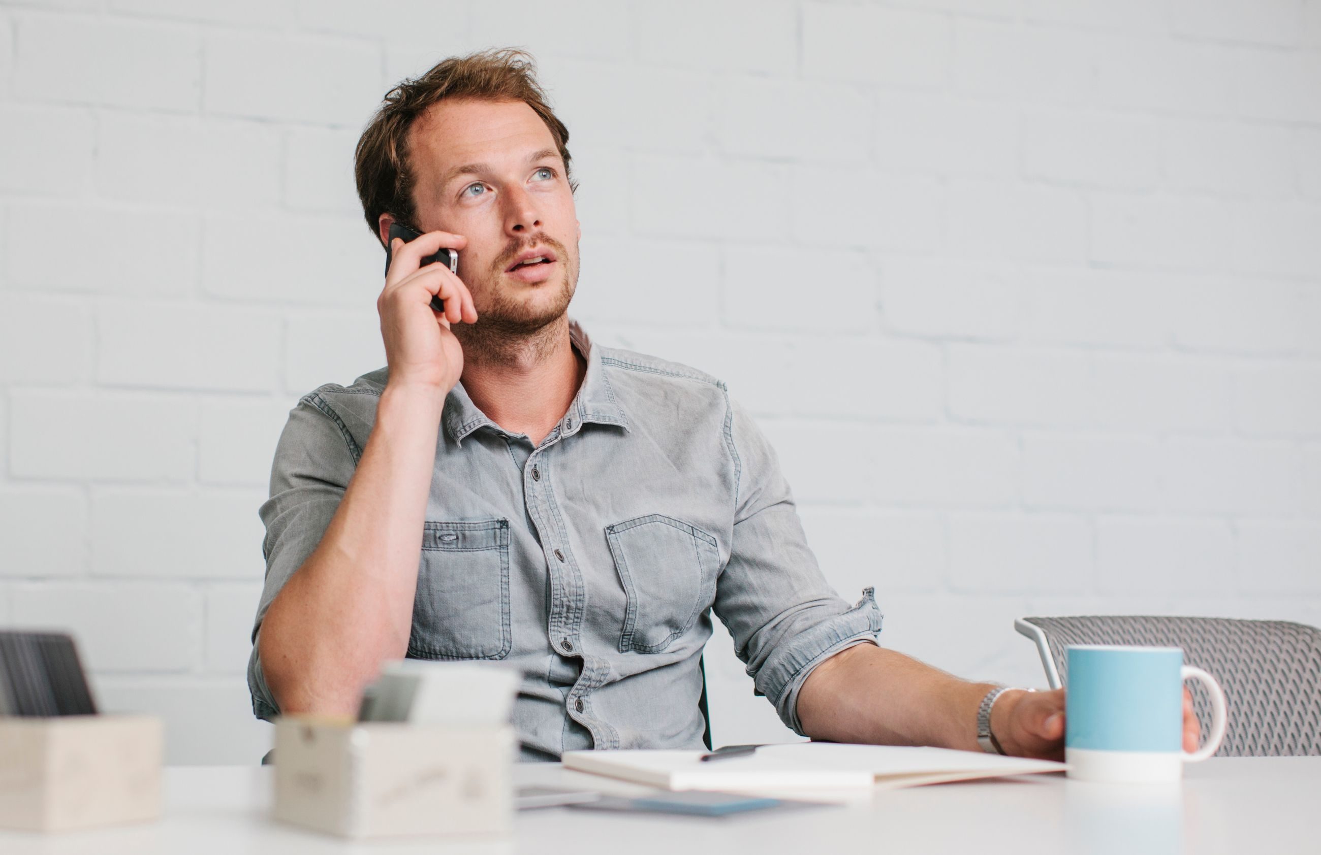 Jobbintervju: Mann sitter i telefonen ved et bord.