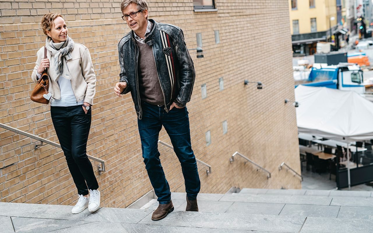 Humør: En blid kvinne går opp en trapp sammen med en mann som snakker.