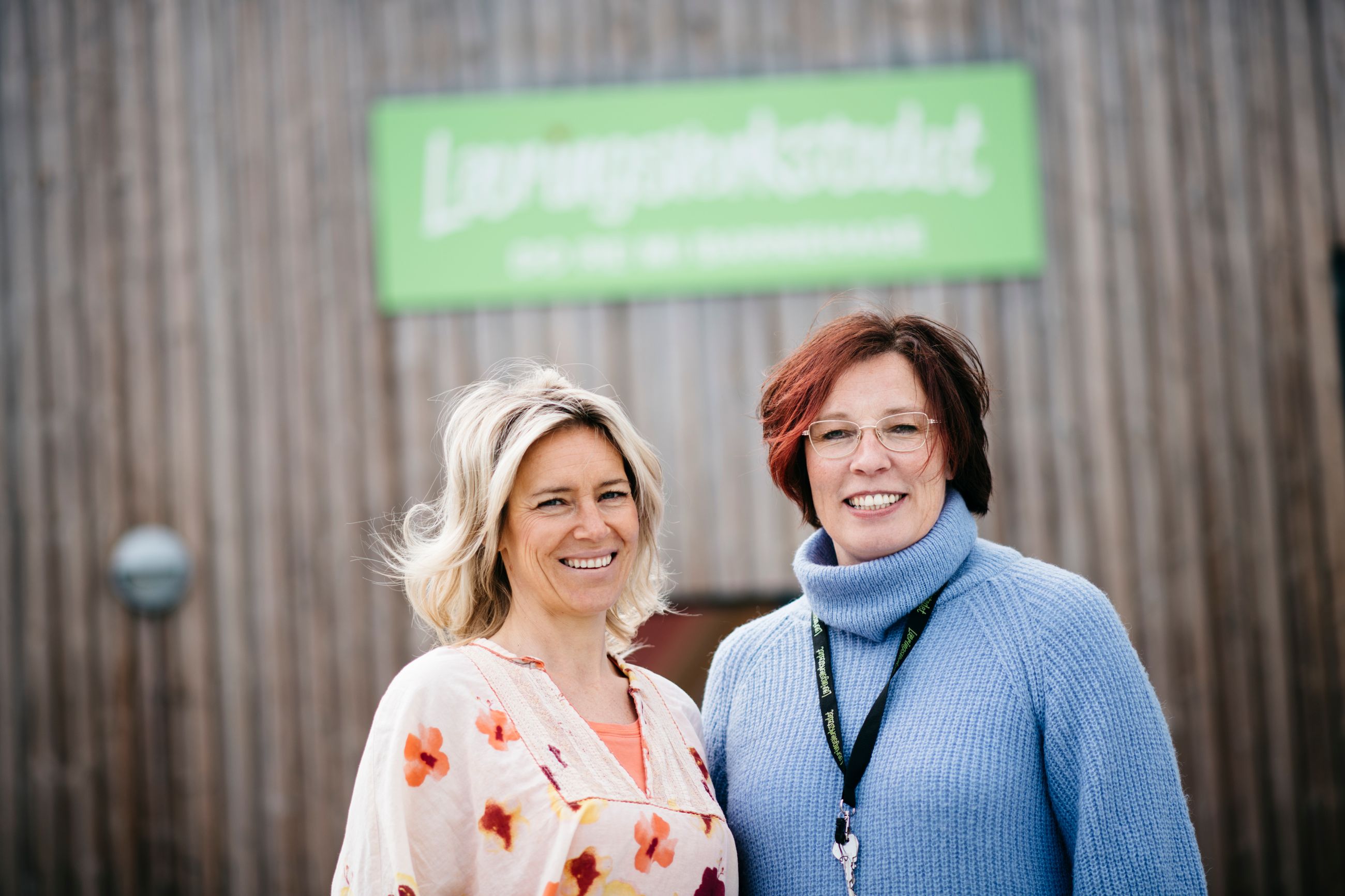 IA-bedrift: To blide kvinner står utenfor en barnehage.