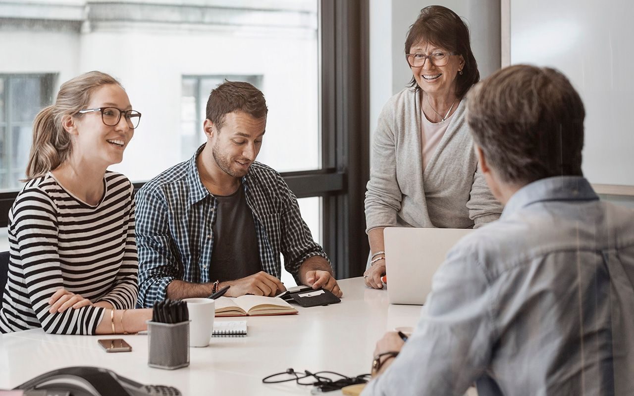 Tilbakemeldinger: Fire kolleger snakker med hverandre rundt et bord.
