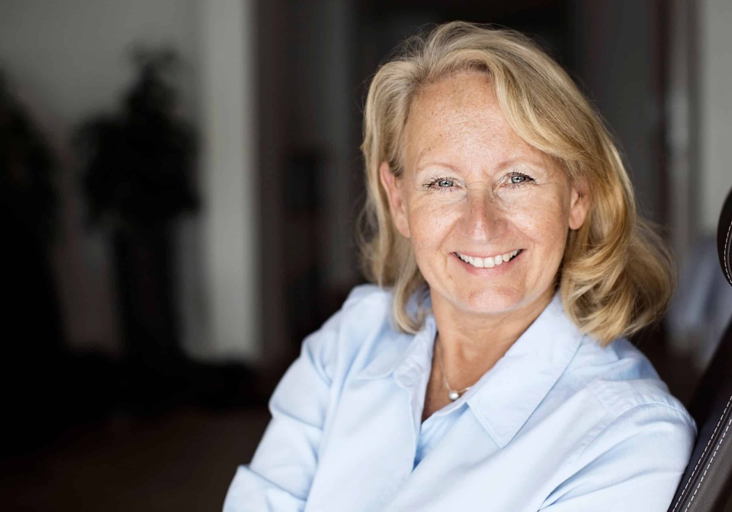 Empati: En voksen, blond kvinne smiler mot kameraet.