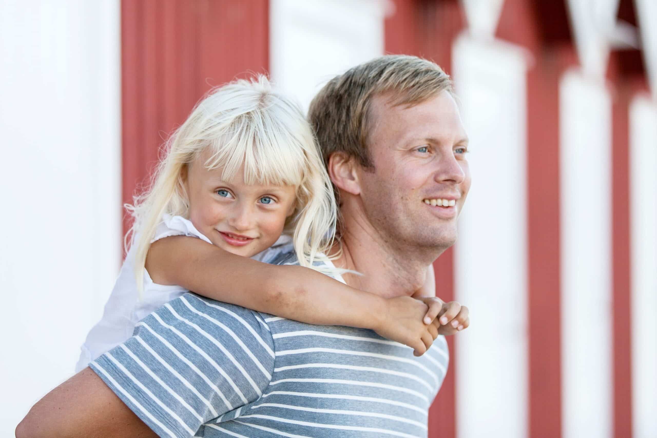 Mestring: Blond jente siter på ryggen til en voksen mann.