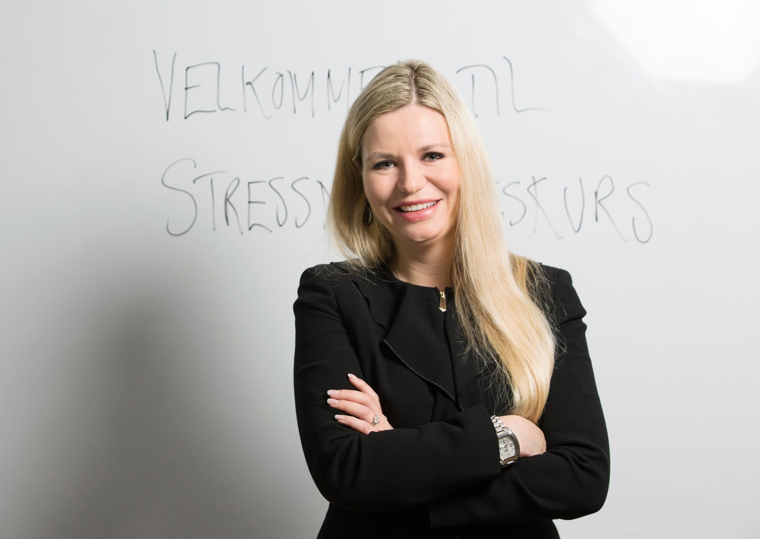 Stress: Kvinne med langt lyst hår står foran en hvit tavle med skrift.