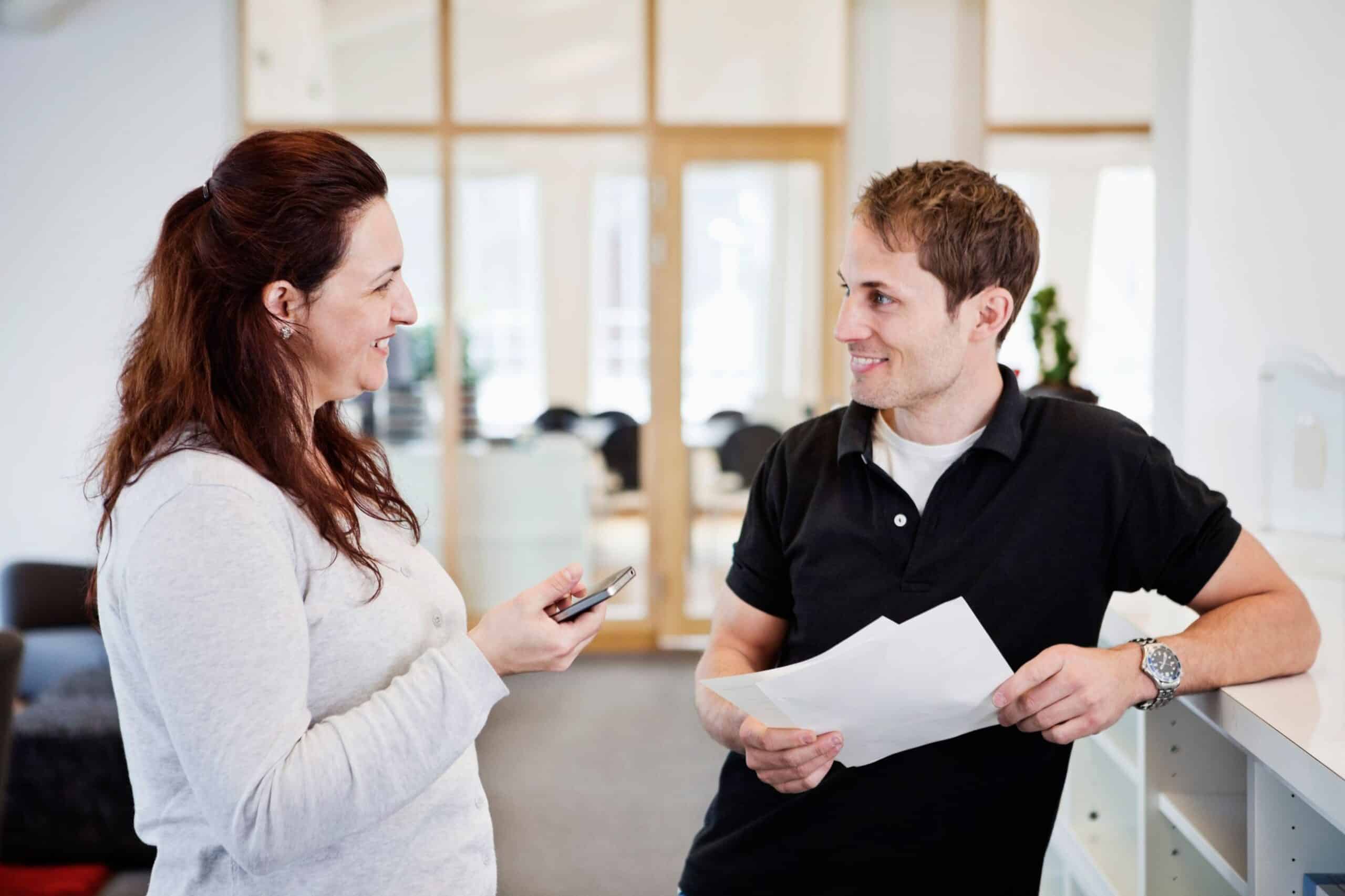 Dialog: En kvinne og en mann prater sammen. Begge smiler.