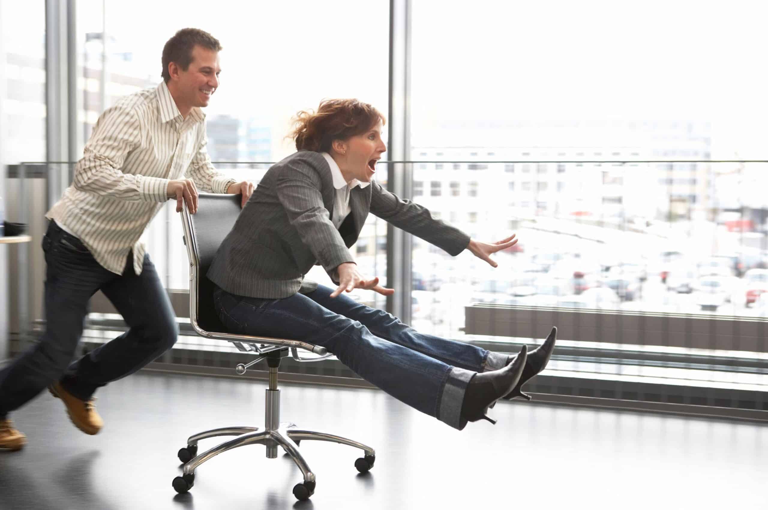 Humor: En mann dytter en kvinne i kontorstol i stor fart.