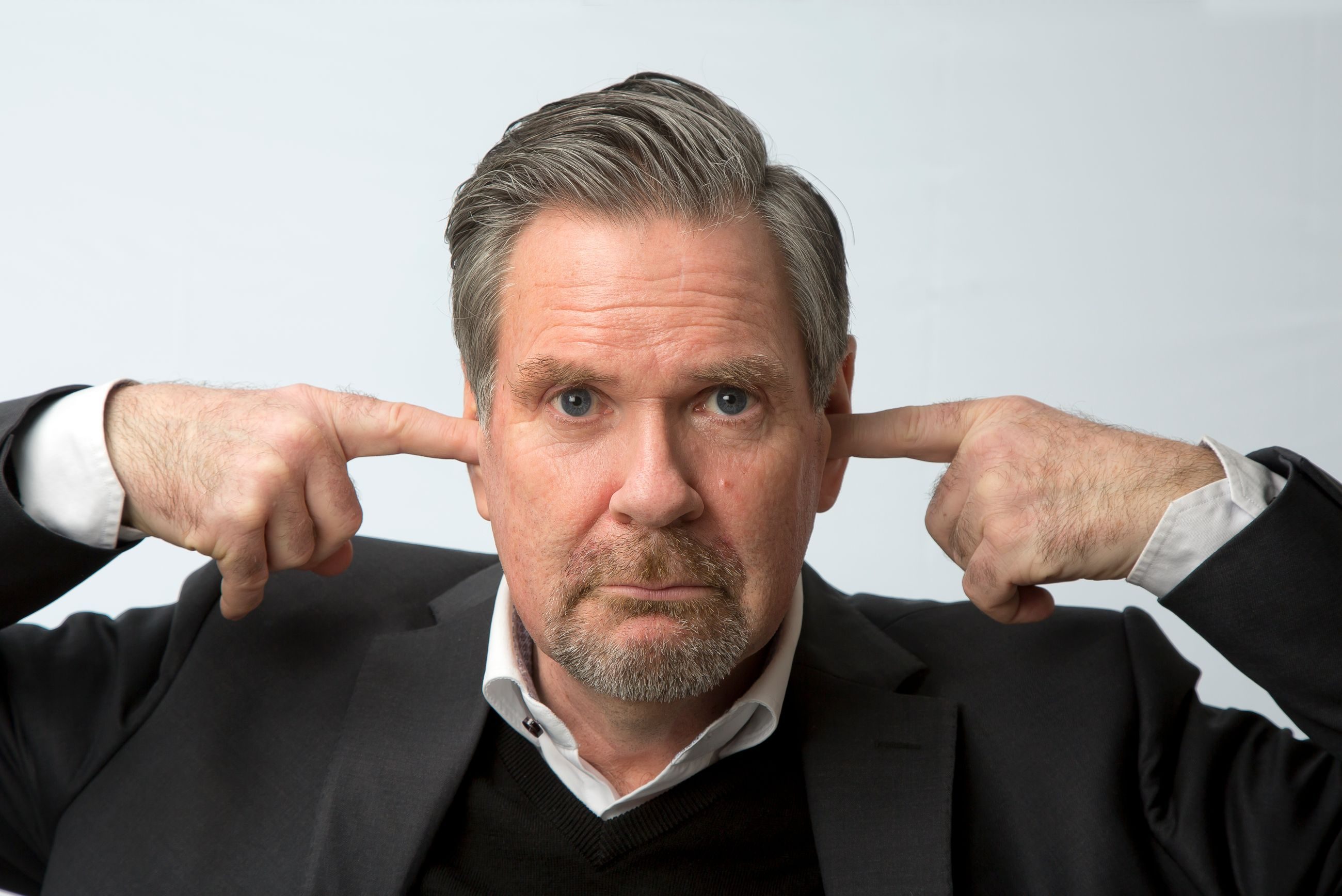 Humor: Voksen mann stikker en pekefinger i hvert øre.