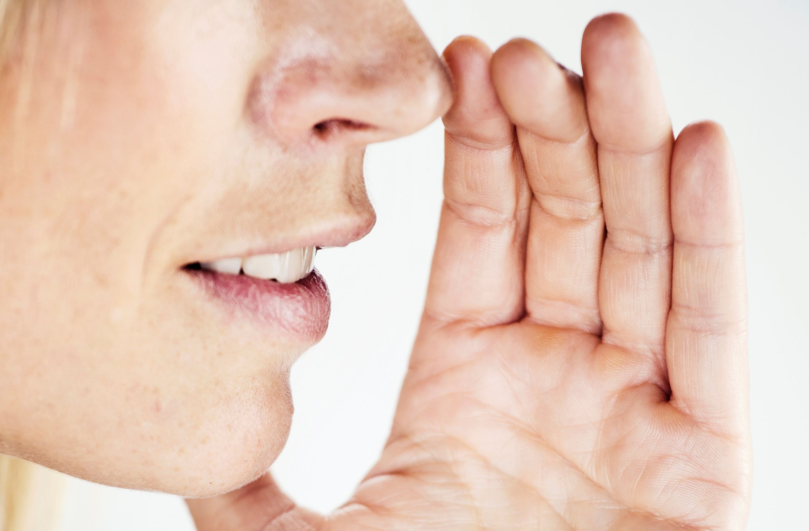 Rollemodell: Nærbilde av en kvinne som snakker lavt med hånden mot munnen.