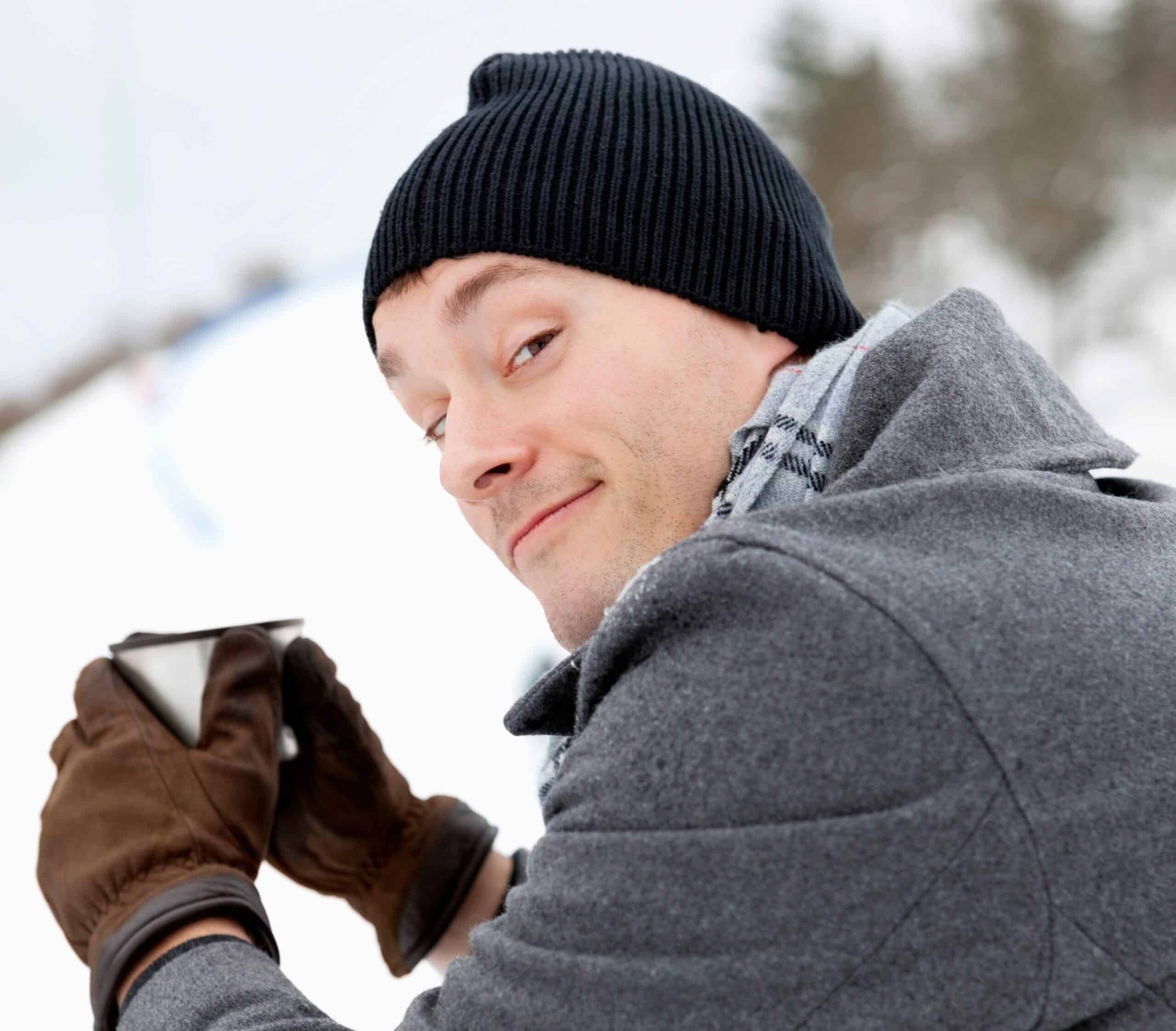 Søvnproblemer: Mann drikker av et krus ute om vinteren.