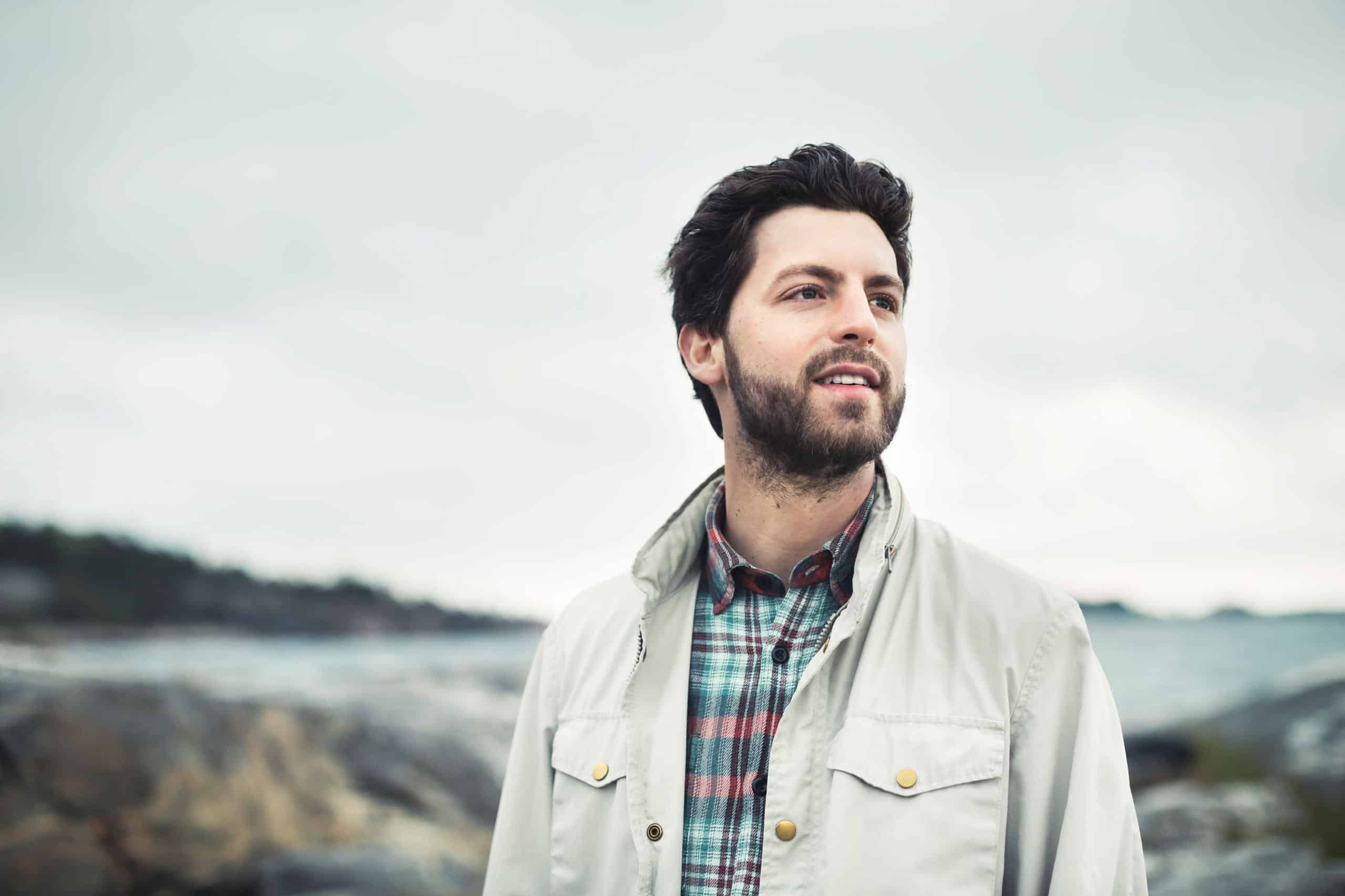 Karriere: Mann med skjegg står ute ved sjøen.