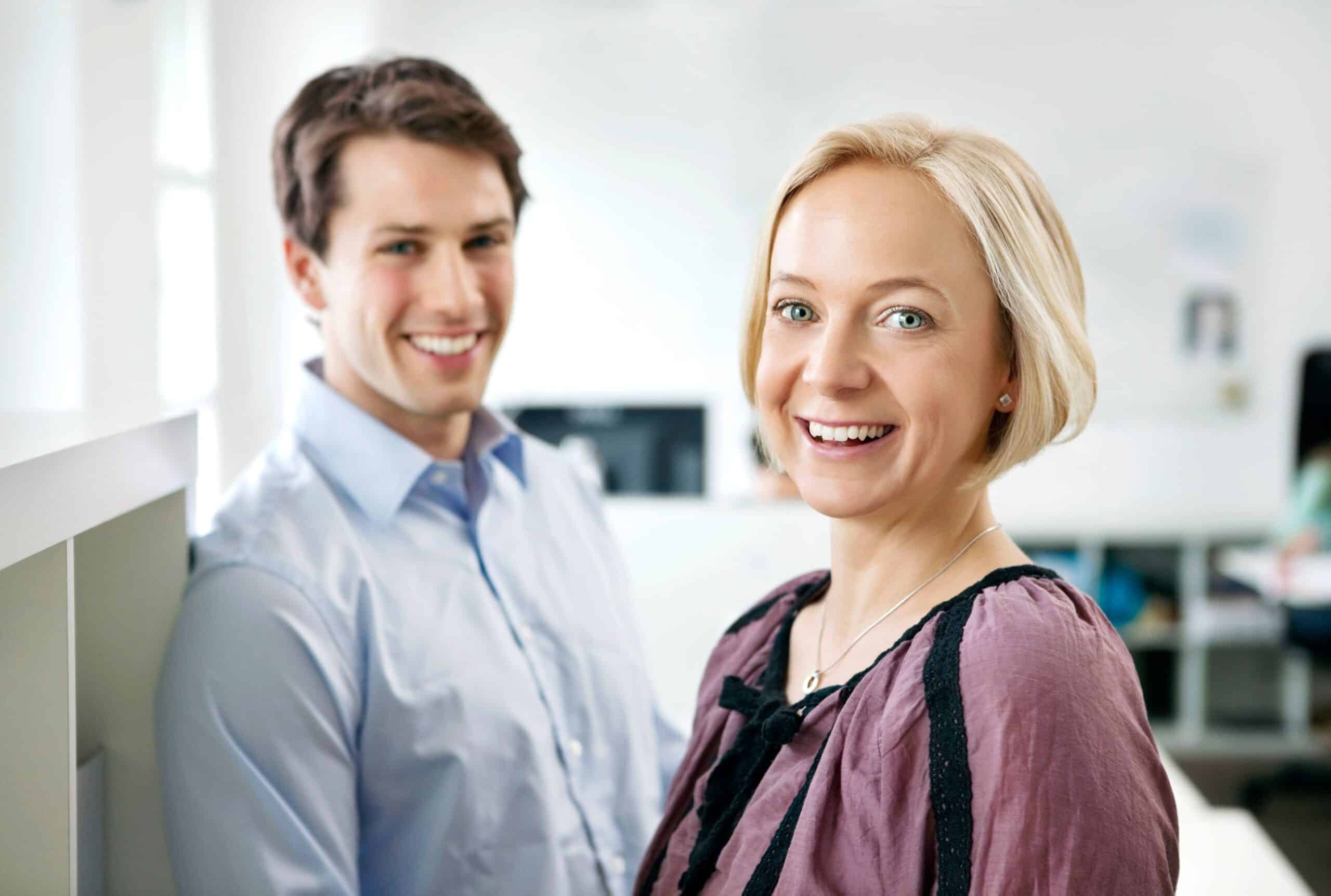 Karriere: En ung kvinne smiler i forgrunnen, og litt bak står en blid ung mann.