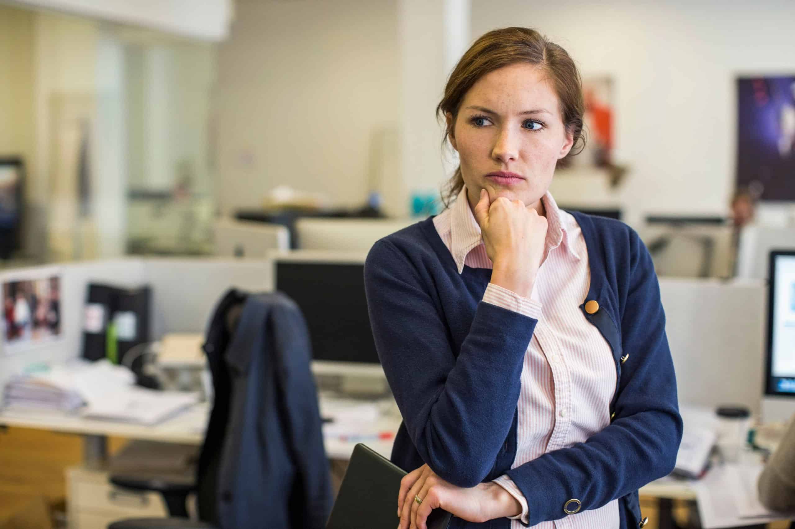 Ansvarsfraskrivelse: En litt mutt kvinne står i et kontorlandskap.