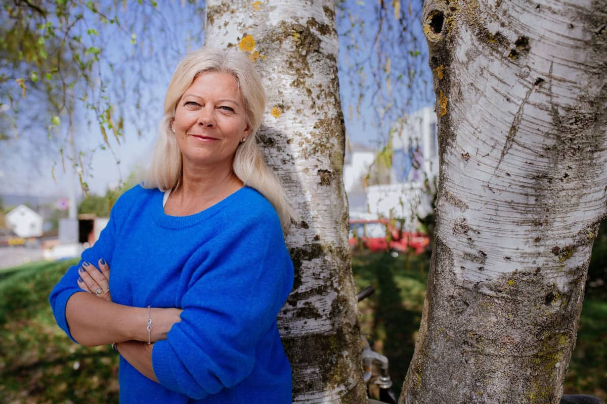 Krise: Kvinne står lent mot en bjørketre. Til sak om ledertips i koronatider