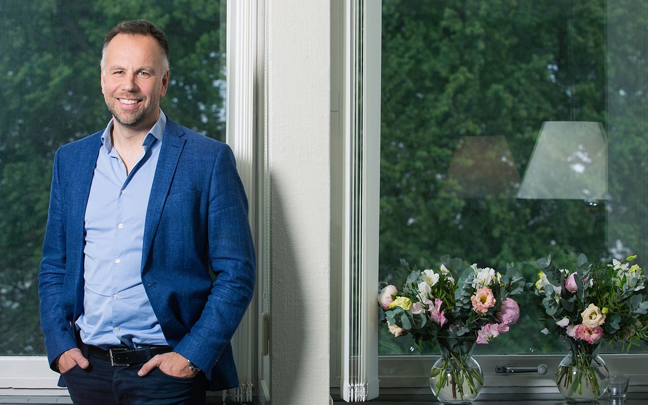 Krise: Mann står foran et vindu. En blomsterbukett ses nede til høyre.