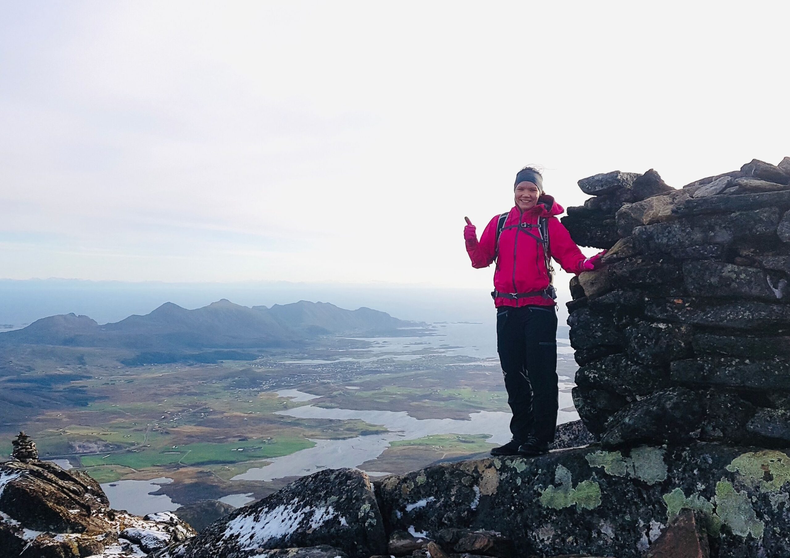 Leder: Ung kvinne står på en fjelltopp.