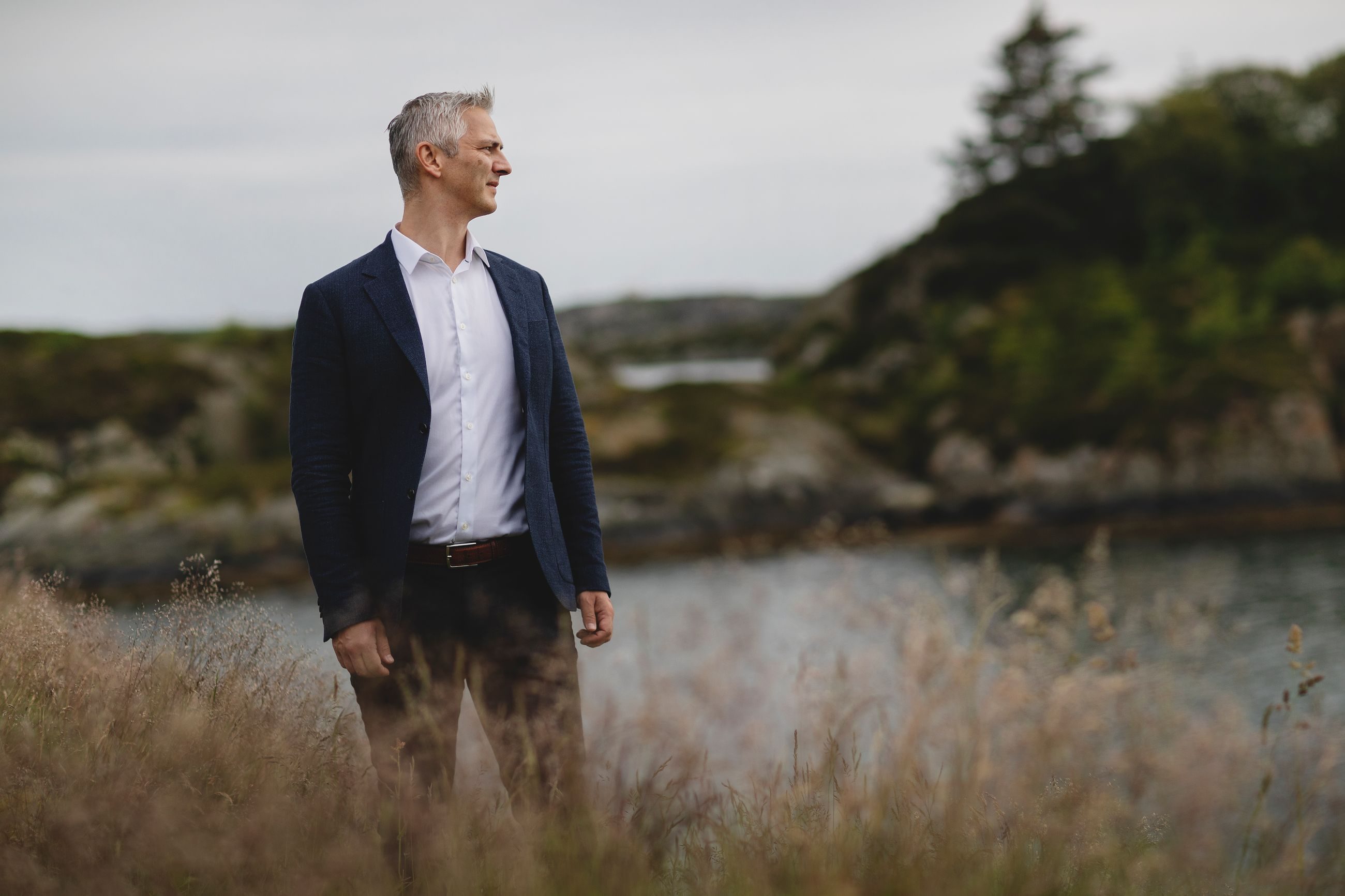 Kroppsspråk: Mann står ute i vakkert landskap og ser til siden.