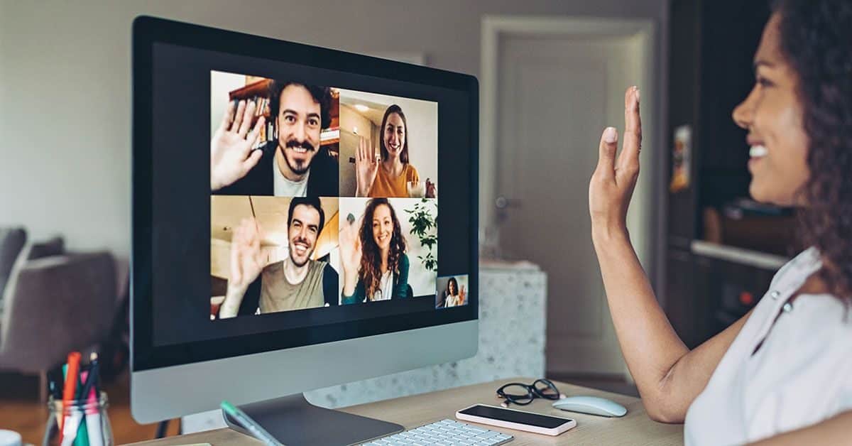 Kvinne er på teamsmøte og vinker til skjerm