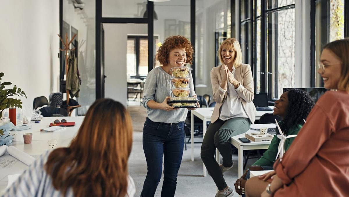 kvinne som har hentet mat til sosialt arrangement på jobben