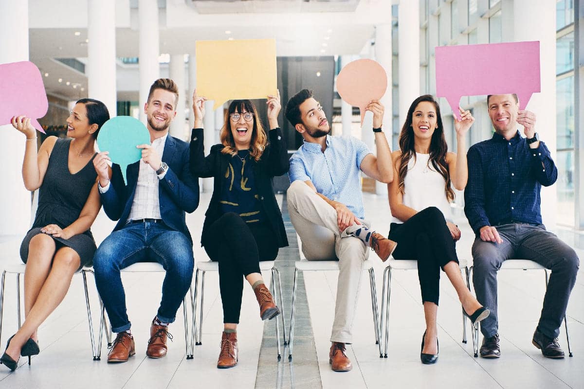 Kvinner og menn som sitter ved siden av hverandre og holder oppe ulike snakkbobler for å illustrere ulike metoder for kommunikasjon