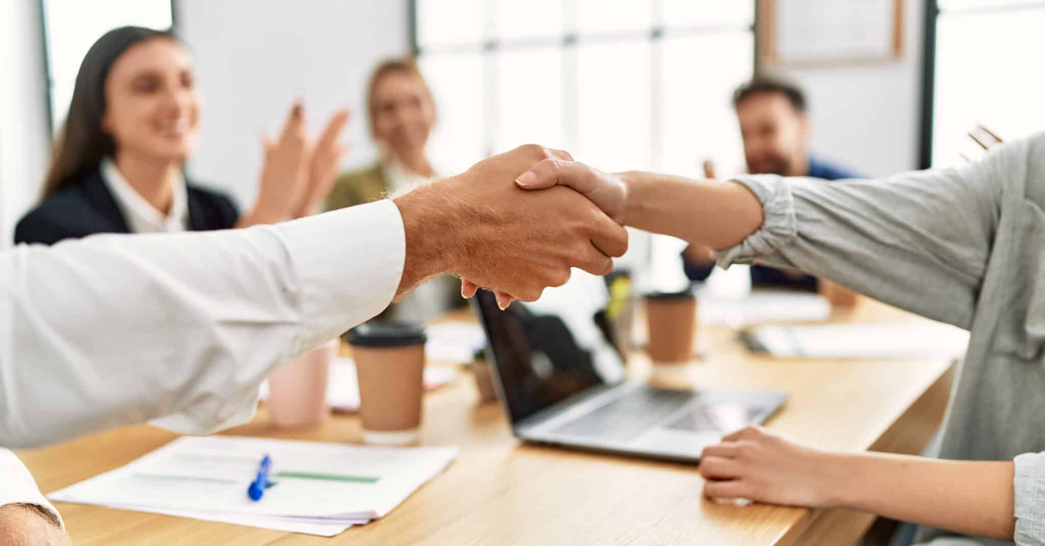 Bilde av et håndtrykk mellom to kollegaer.