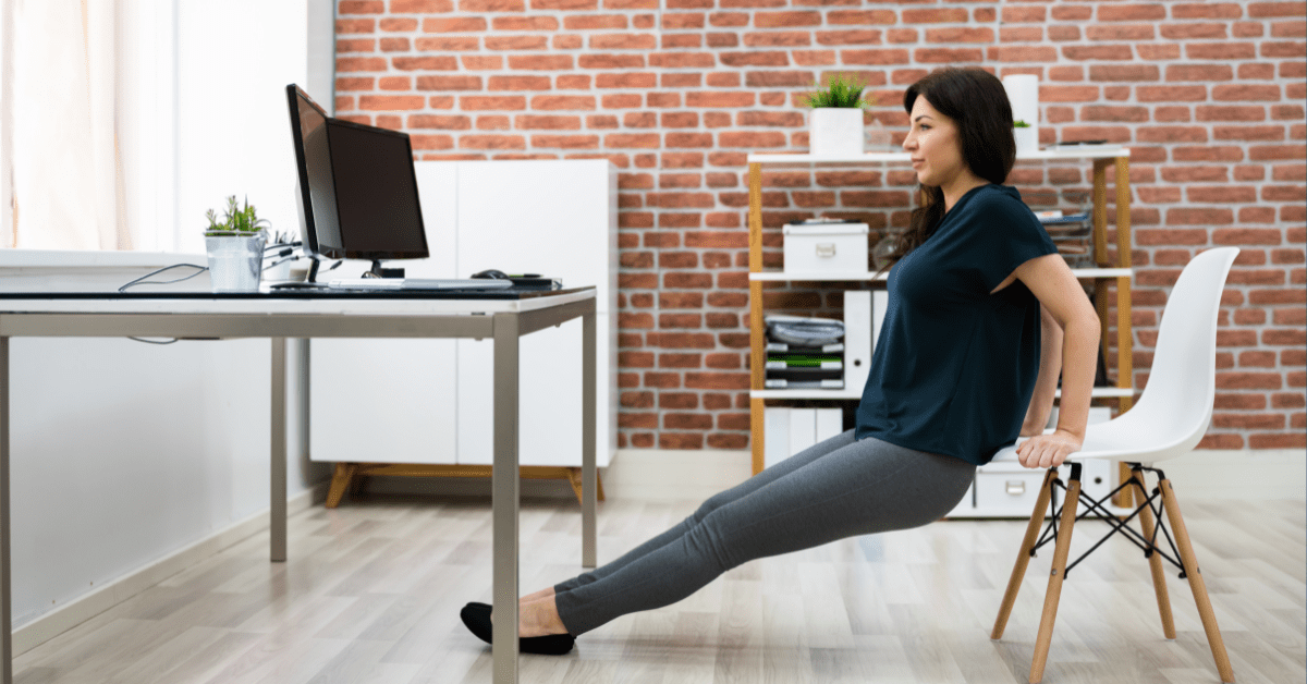 Dame som trener armer foran PC ved bruk av stol