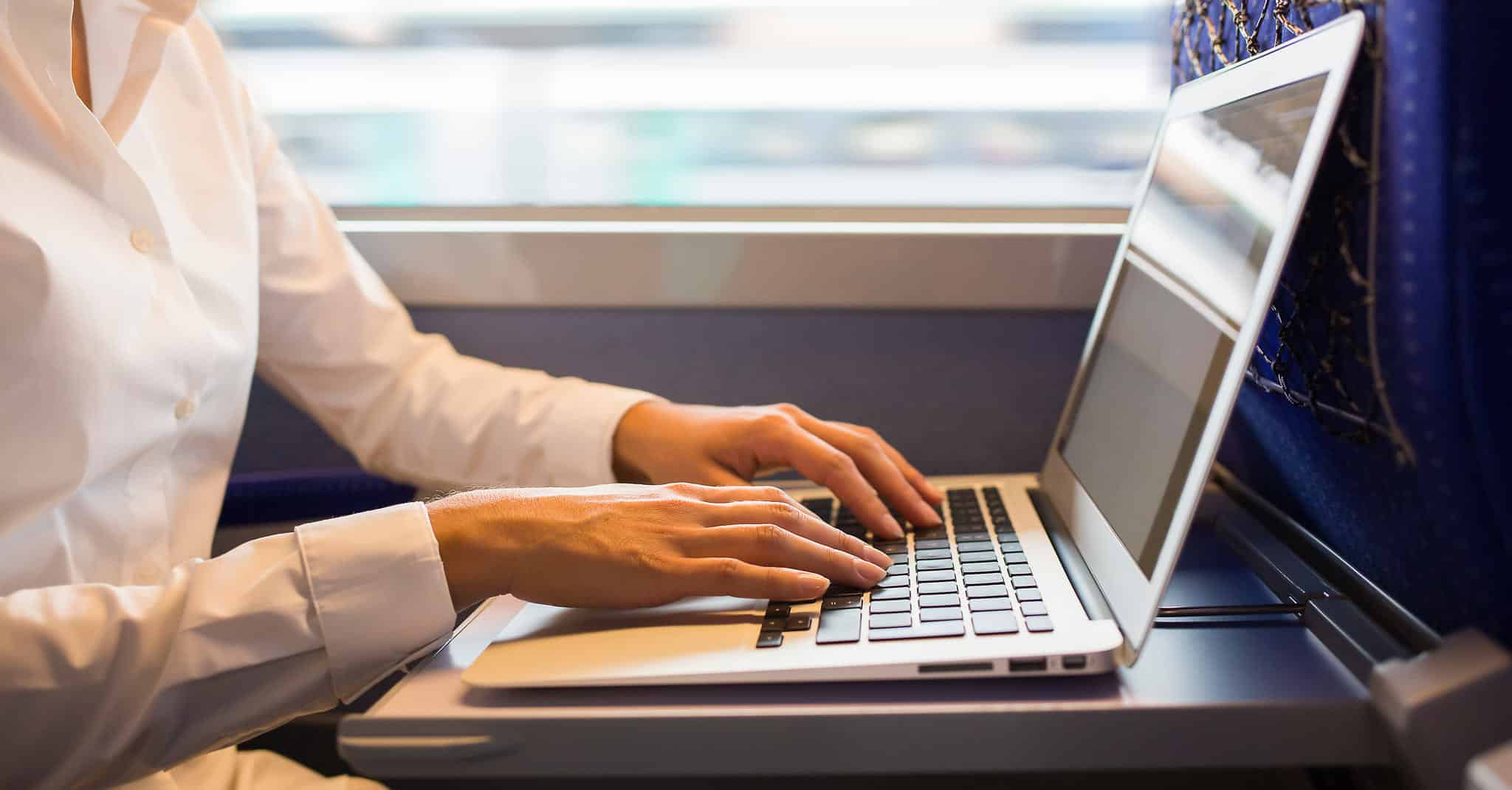 En kvinne som sitter på toget og jobber.