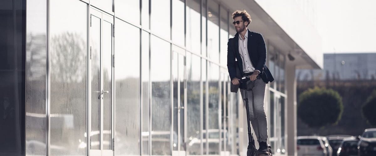 Mann på sparkesykkel.