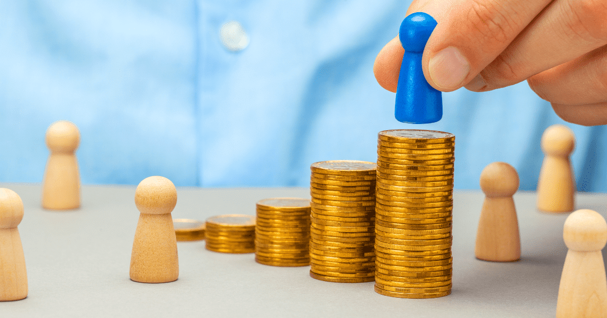 Stockbilde av mynter og en hånd som plasserer en brikke på pengene