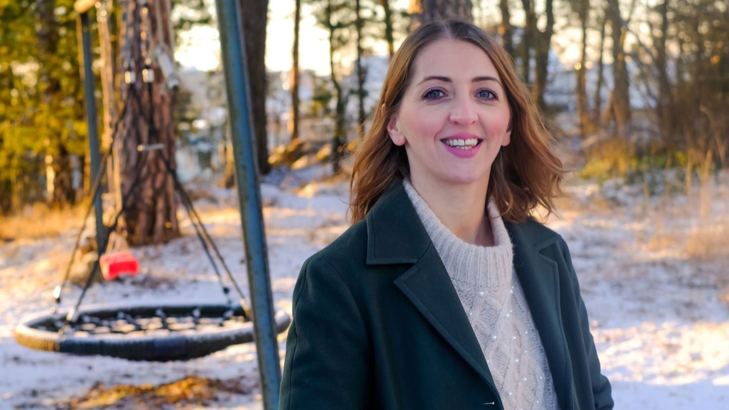 Portrrett av Jana Jarosova stående med lekeplass bak seg