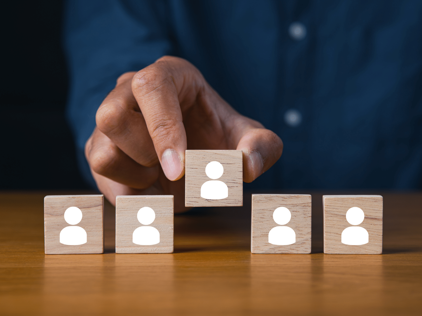 5 klosser med personikon. En hånd løfter en av klossene.