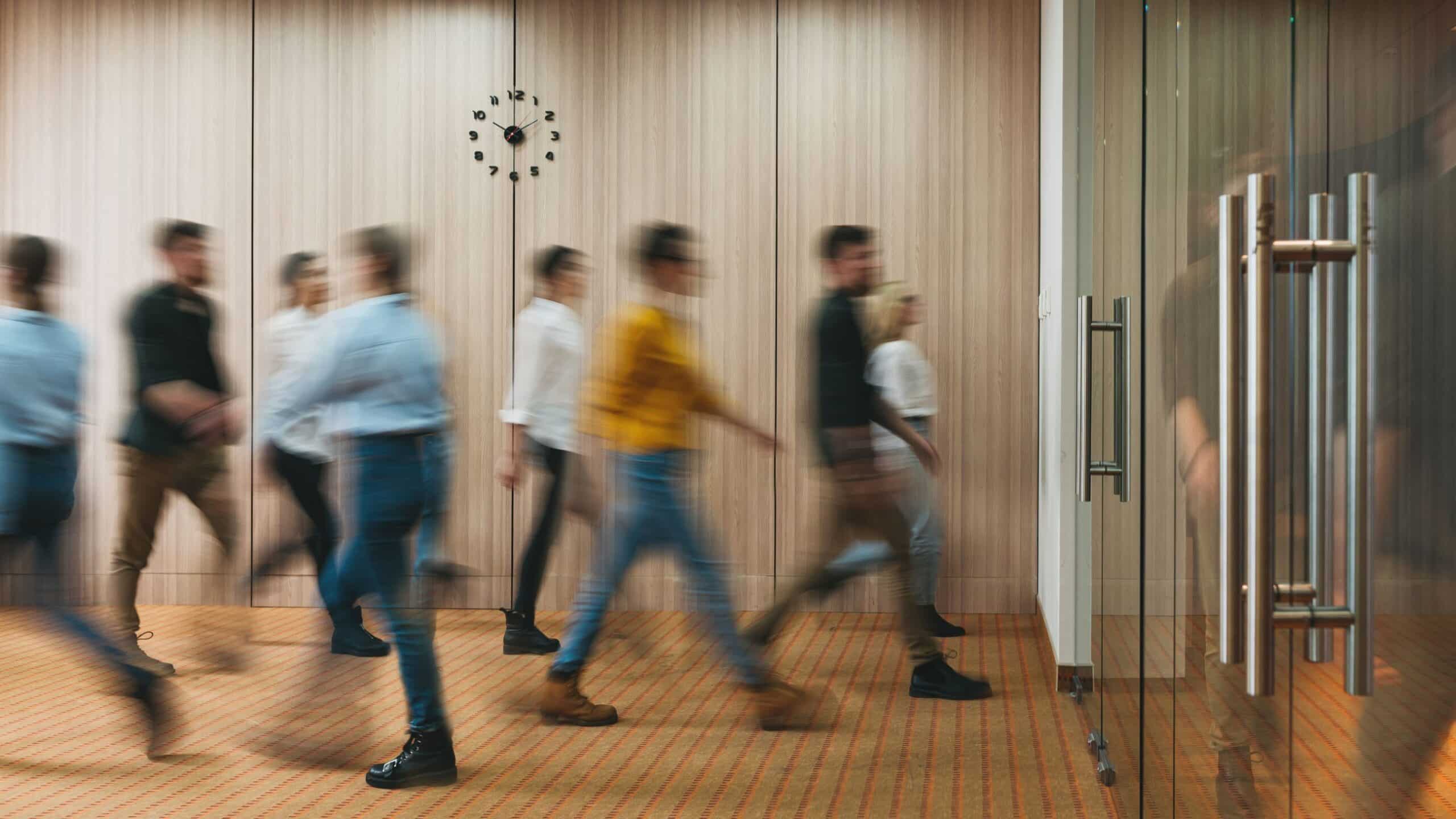 Mennesker som har det travelt i gangen på et kontorlokale