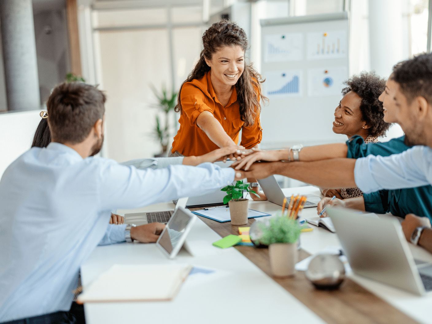 Et team på fem personer som holder knokene mot hverandre.