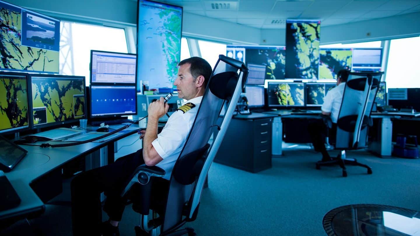 Man som sitter og snakker inne på Fedje sjøtrafikksentral