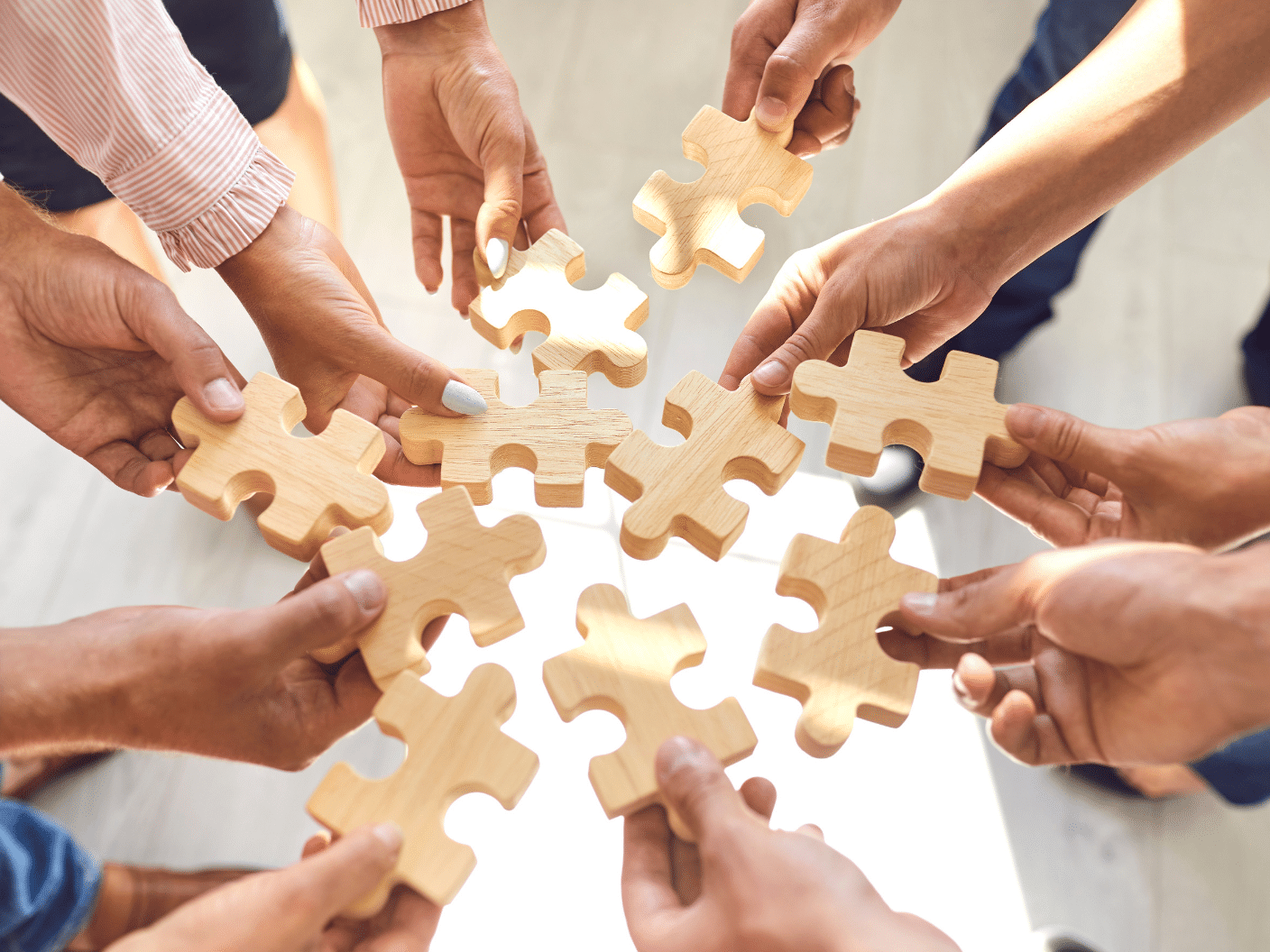 Hender som holder puslespillbrikker mot hverandre.