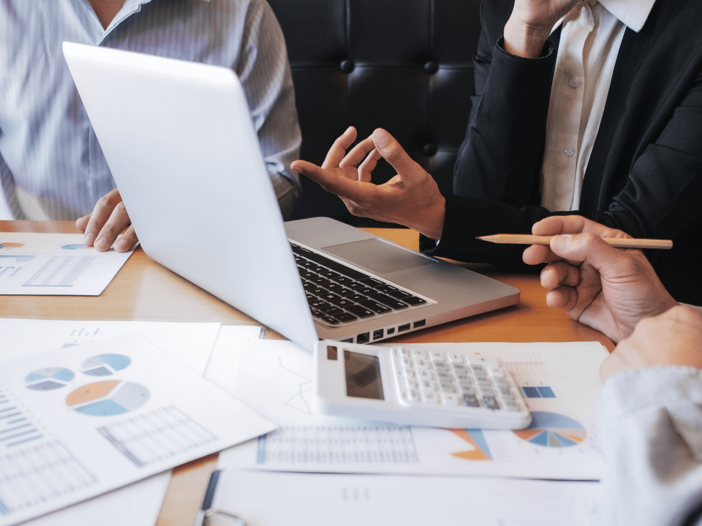 Mennesker foran PC og utskrifter med grafer og tall