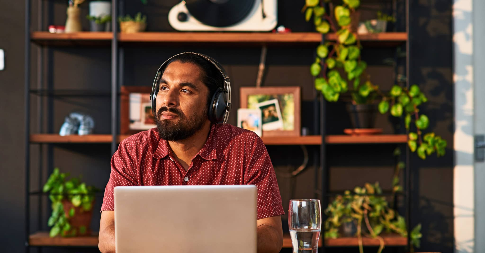 Mann har høretelefoner på foran en pc.