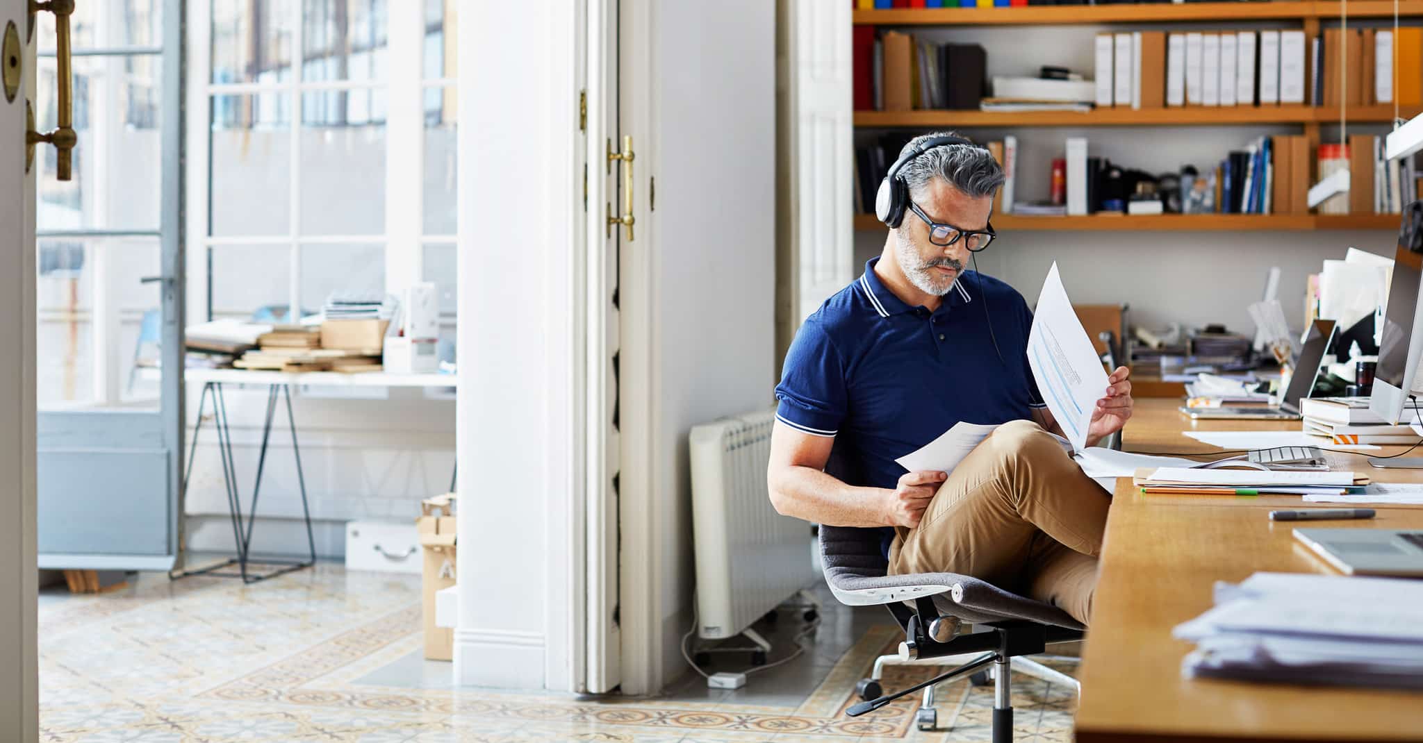 Mann hører på musikk og arbeider.