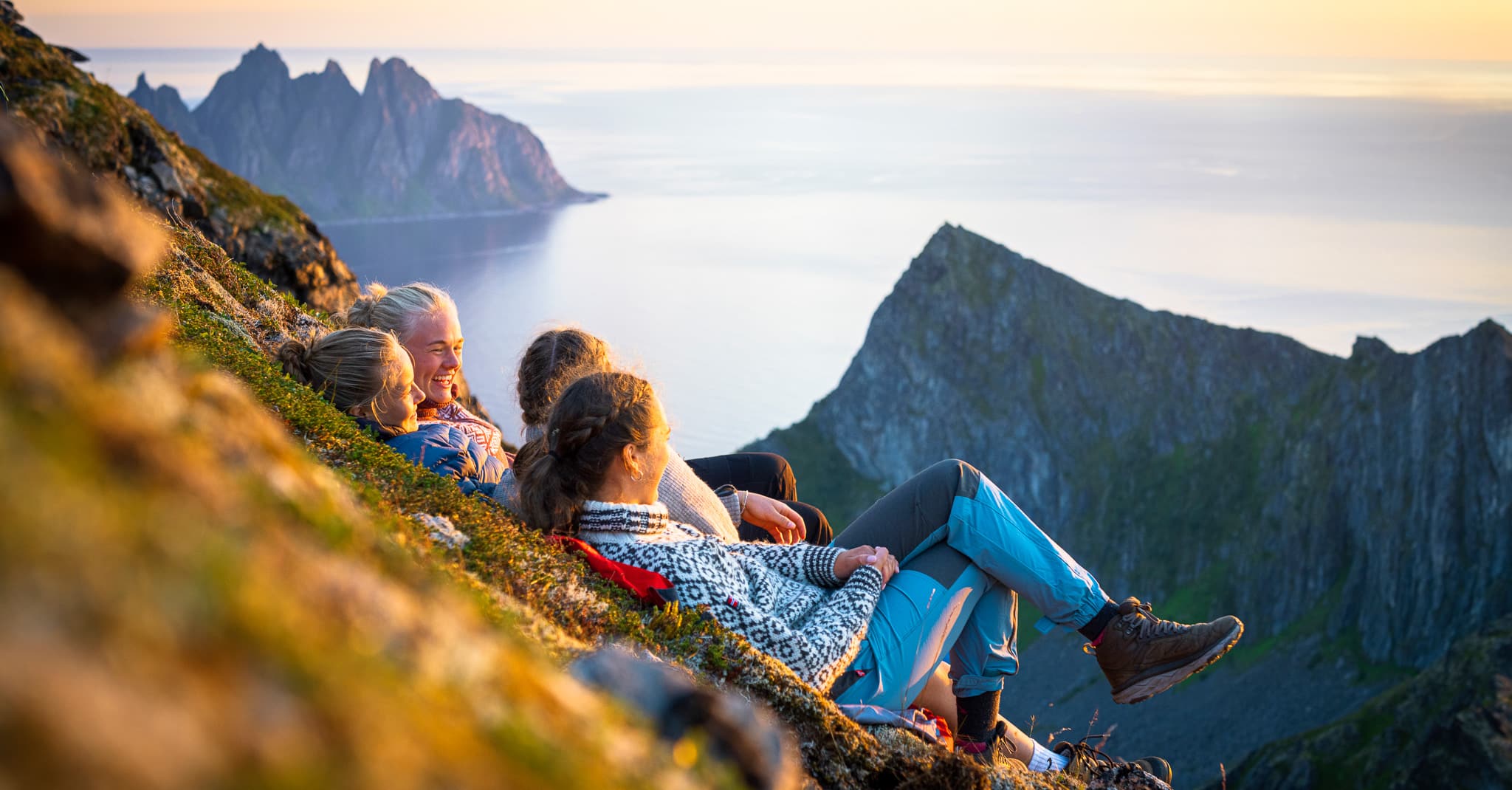 En jentegjeng ser utover en flott havutsikt.