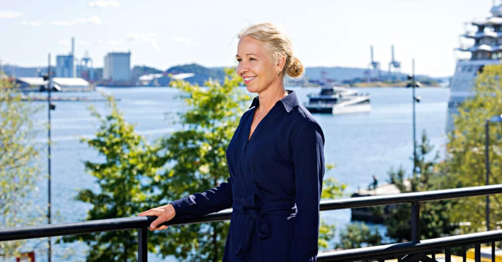 Hedda Felin står ved en fin utsikt med en havn.