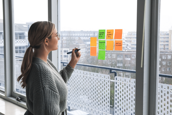 Kvinne som skriver på post it lapper