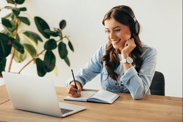 Dame som sitter foran PC og deltar på webinar