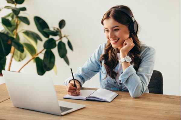 Dame som sitter foran en PC og deltar på webinar