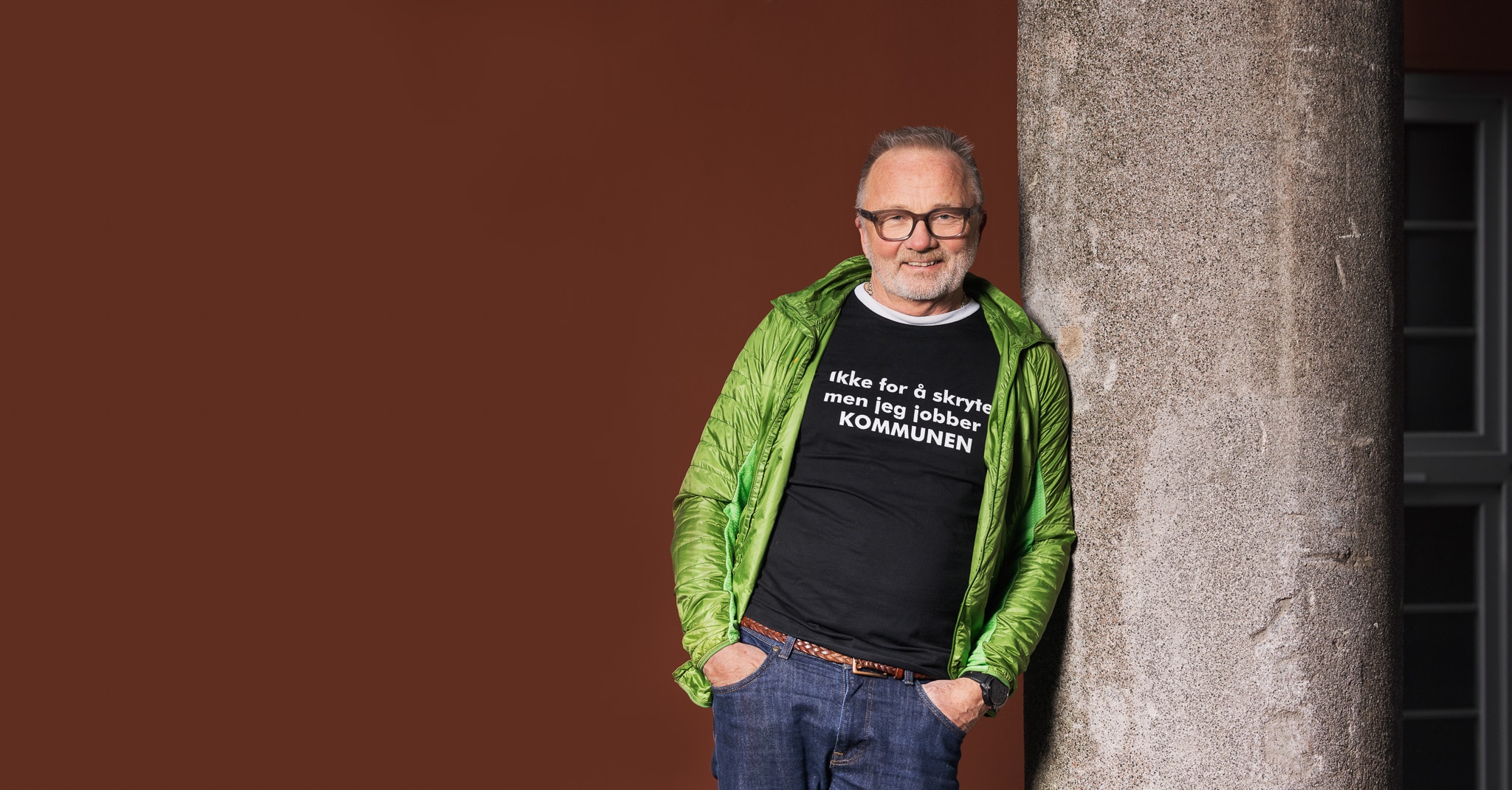 Øyvind Henriksen står lent mot en betongsøyle og smiler.